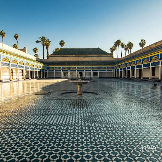 A courtyard of the Bahia Palace in Marrakech — ornate carved stucco arches, painted cedar ceilings and a central fountain set in traditional zellige tilework represent the most complete surviving example of traditional Moroccan palatial architecture, built in the late 19th century for Grand Vizier Si Moussa